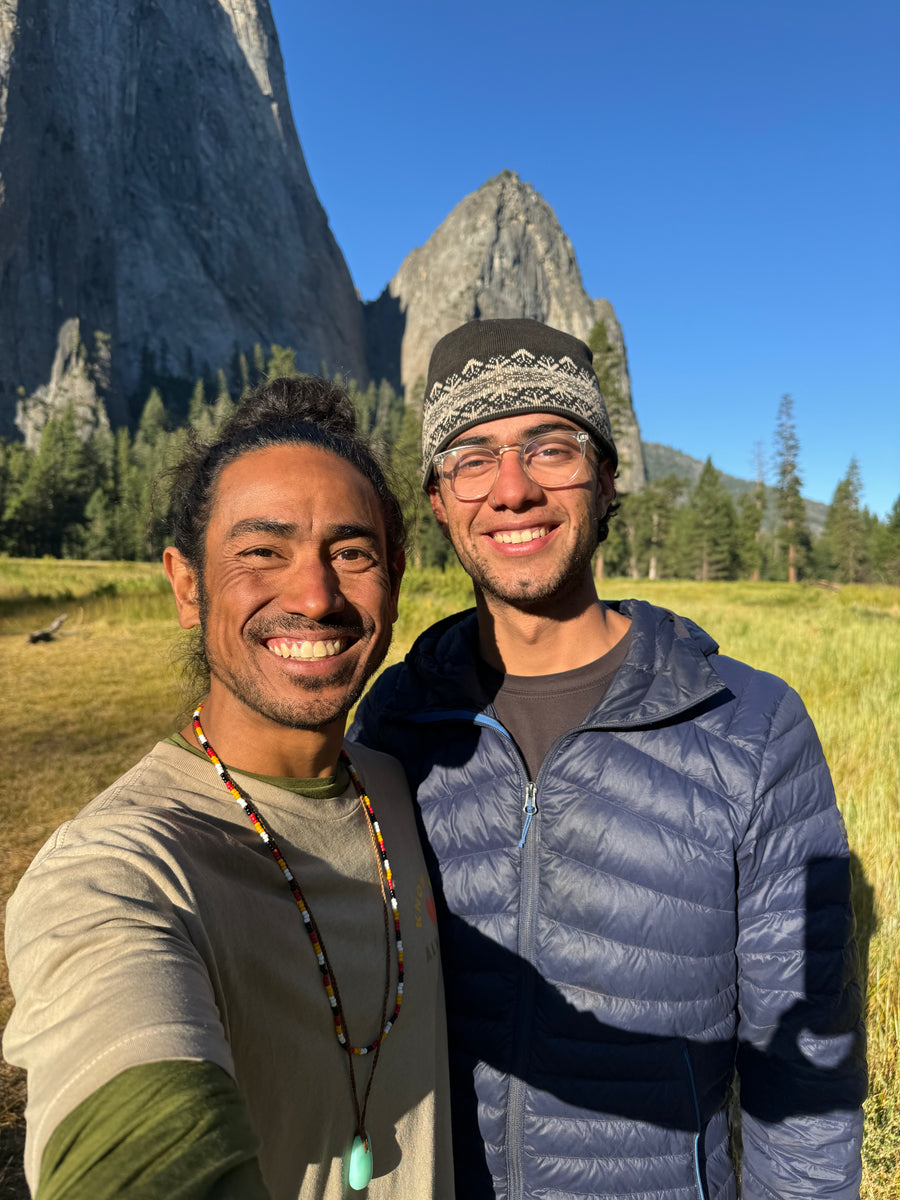 Two smiling men taking a selfie outdoors