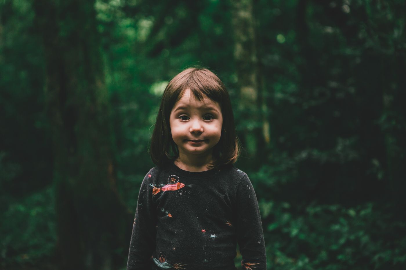A young person in a green forest