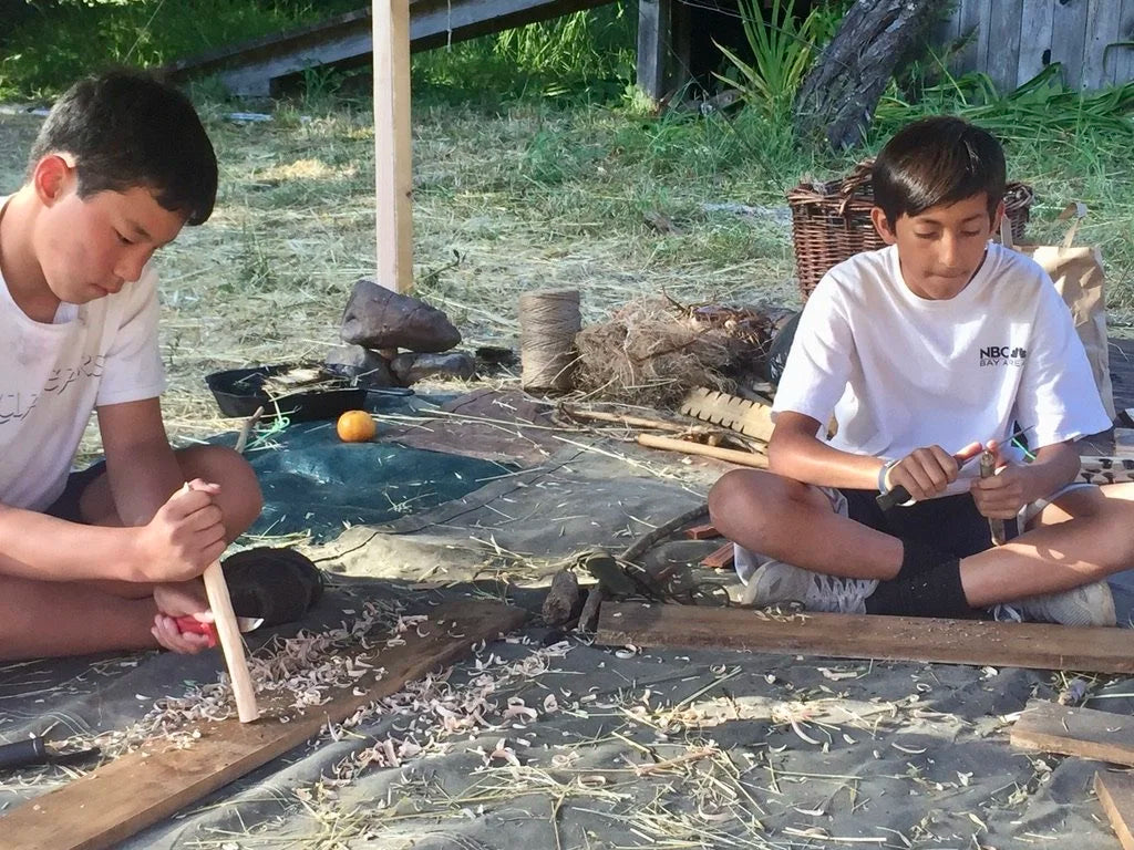 Two boys working on crafts outdoors