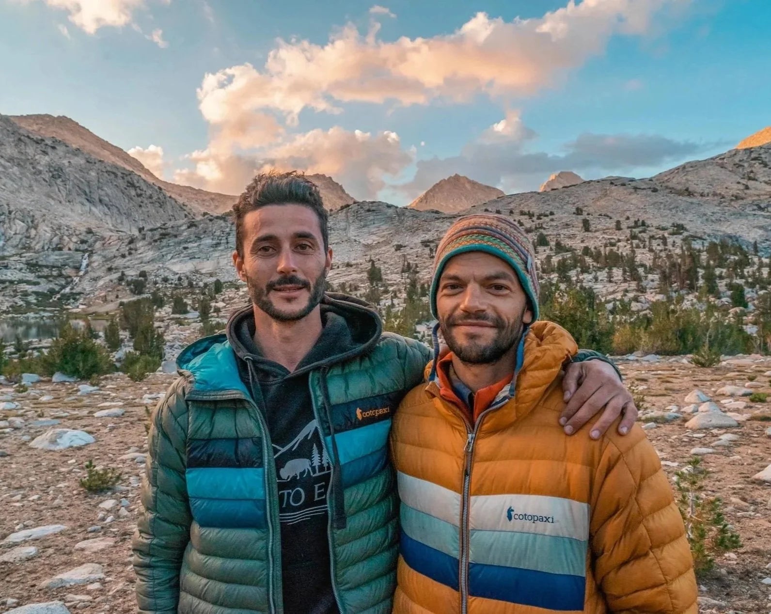 Two men in the mountains at sunset
